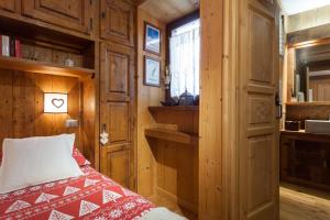 een kleine slaapkamer met een bed en een raam bij L'Atelier du Temps - CHARME in Courmayeur in Courmayeur