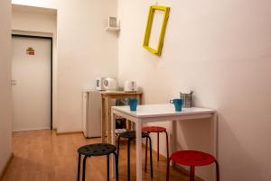 a room with a table, chairs, and a refrigerator at Clown and Bard Hostel in Prague