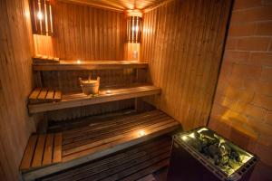 a sauna with a bench and a bucket in it at Azoris Faial Garden – Resort Hotel in Horta