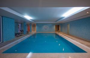 a large swimming pool in a room with blue walls at Azoris Faial Garden – Resort Hotel in Horta