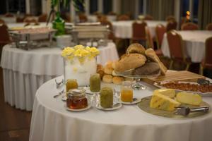 a table with cheese and bread and other food on it at Azoris Faial Garden – Resort Hotel in Horta