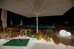 a table with fruits and shoes and an umbrella at Azoris Faial Garden – Resort Hotel in Horta