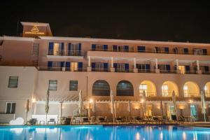 a hotel with a swimming pool in front of a building at Azoris Faial Garden – Resort Hotel in Horta