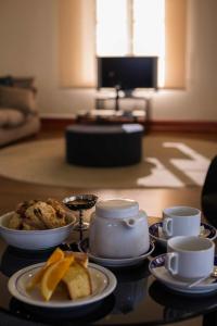 a table with plates of food and cups on it at Azoris Faial Garden – Resort Hotel in Horta
