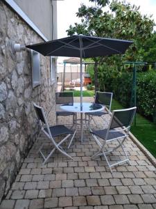einen Tisch und zwei Stühle und einen Regenschirm auf einer Terrasse in der Unterkunft Villa Cottreau in Marseille
