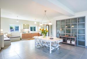 a kitchen and living room with a white table and chairs at Villa Serenis in PorovÃ­tsa