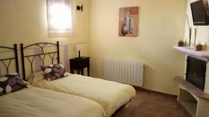 a bedroom with two beds and a fireplace at Casa Rural Mirabueno in Cuenca