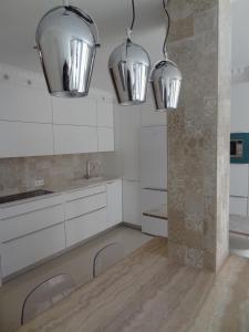 una cocina con armarios blancos y 2 luces en Infostays María Zambrano - Free Parking en Málaga