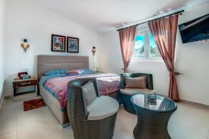 1 dormitorio con 1 cama, 2 sillas y mesa en Sea Oasis Apartments - Milosevic, en Kotor