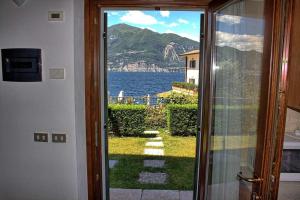 - une porte menant à une chambre avec vue sur l'eau dans l'établissement Aparthotel La Caletta Bolognese, à Brenzone