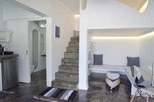 uma sala de estar com uma escada e um sofá em Moschoula Studios em Adamas