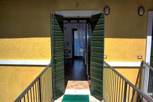 un couloir d'une maison avec un mur vert et jaune dans l'établissement Aparthotel La Caletta Bolognese, à Brenzone