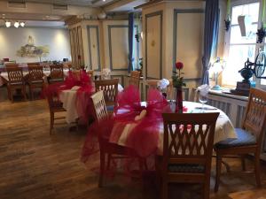 ein Esszimmer mit Tischen und Stühlen mit roten Bögen in der Unterkunft Landgasthof Hotel Rebstock in Stühlingen