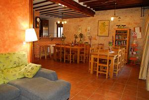 sala de estar con sofá, mesa y sillas en Casa rural Valdecid, en Valdeande