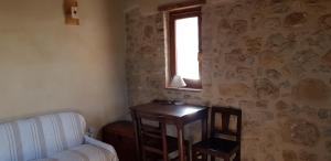 RadicondoliにあるAgriturismo Le Canterieのソファ、テーブル、窓が備わる客室です。