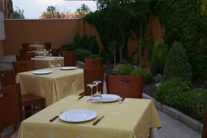 een restaurant met tafels en stoelen met geel tafelkleed bij HOSTAL EL POLIGONO in La Roda