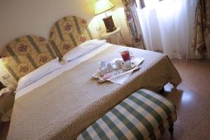 a hotel room with a bed with two chairs and a tray of coffee cups at Fattoria Santa Lucia Borgo alla Cantina in San Gervasio +16 photos