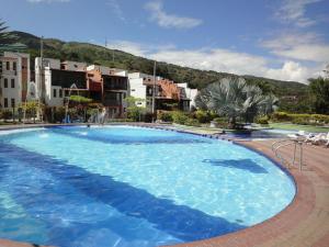 a large blue swimming pool with buildings in the background at Apartasol En San Jeronimo in San Jerónimo