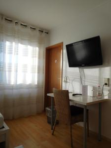 a room with a desk and a tv on the wall at Arkadia Hotel in Burgwedel