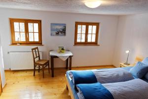 1 dormitorio con 1 cama y 1 mesa con silla en Landhaus Tenne, en Bartholomäberg