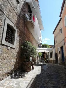 un vicolo con un edificio e un ombrello di Palazzo Pisani Residenza Storica Pollica a Pollica