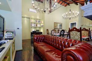 a living room with a leather couch and chairs at Antico Platano in Rome