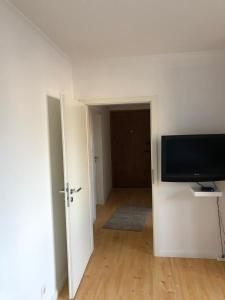 an empty room with a flat screen tv and a hallway at De Isenboner Wankendorf in Wankendorf