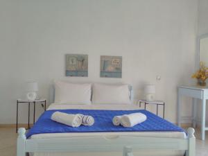 a bedroom with a large bed with towels on it at Enalion Apartments in Agios Ioannis Kaspaka