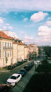 華沙的住宿－Przytulny apartament przy Barbakanie，一条城市街道,汽车停在建筑前