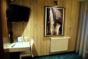 a room with a wall with a television and a desk at Dark Pub Hotelik in Gorlice