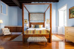 um quarto com uma cama de dossel com uma estrutura em madeira em Camoes by Central Hill Apartments em Lisboa