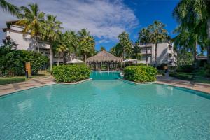 a large swimming pool in a resort with palm trees at Balcones Beach Penthouse in Las Terrenas