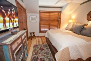 um quarto com uma cama e uma televisão de ecrã plano em Penthouse By The Gondola em Telluride