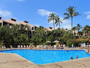 a swimming pool at a resort with people in it at CASTLE Kama'ole Sands in Wailea
