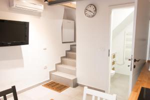 a staircase in a living room with a clock on the wall at Koper2stay in Koper