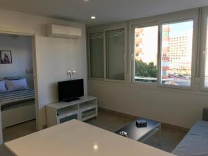 uma sala de estar com televisão e uma cama e janela em Apartamento Sol y Mar em Torremolinos