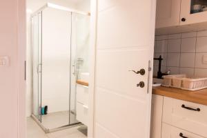 una puerta de ducha de cristal en una cocina blanca en Koper2stay, en Koper