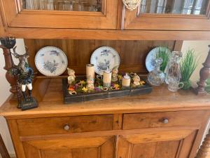 a wooden cabinet with plates and candles on it at Appartement Wissembourg in Wissembourg