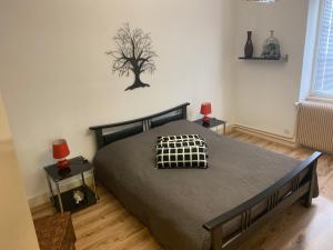 a bedroom with a bed with a tree on the wall at Appartement Wissembourg in Wissembourg