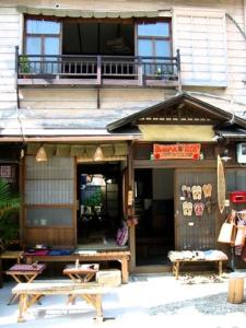 a building with two benches in front of it at Buddha Guest House in Tanabe