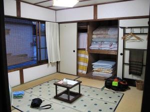 um quarto com uma mesa no meio de um quarto em Buddha Guest House em Tanabe