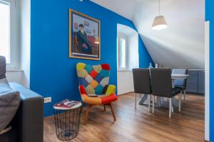 ein Wohnzimmer mit blauen Wänden sowie einem Tisch und Stühlen in der Unterkunft Captain's Place in Dubrovnik