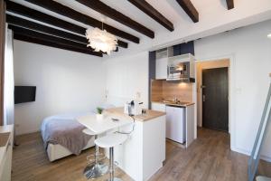 a bedroom with a bed and a desk and a kitchen at ★ LE CÔTÉ GARONNE ★ HYPERCENTRE ★ NETFLIX ★ in Toulouse