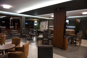a restaurant with tables and chairs and a bar at SANTO Hotel in Shkodër
