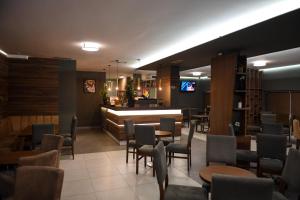 a restaurant with chairs and tables and a bar at SANTO Hotel in Shkodër