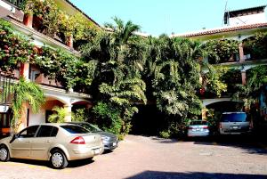 two cars parked in a parking lot in front of a building at HOTEL POSADA DEL SOL in Apatzingán de la Constitución