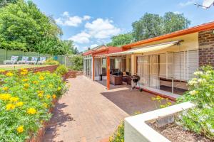 a house with a patio and a garden with flowers at Chalet no. 2 Petunia in Johannesburg