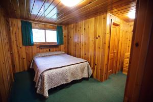 ein Schlafzimmer mit einem Bett in einer Holzhütte in der Unterkunft Idlewilde by the River in Estes Park