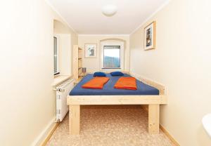 a bedroom with a blue bed with two pillows on it at Bergoase Hütte und Hostel Sauna Kamin Lagerfeuer in Mittelndorf