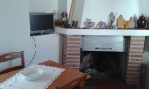a living room with a fireplace with a television and a table at rurale in Nocera Terinese